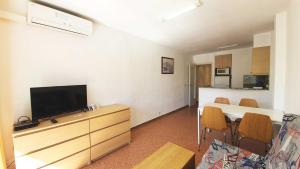 a living room with a television and a table with chairs at Rocamaura IV-2-9 Inmoestartit in L'Estartit
