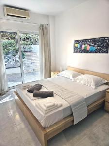 a large bed in a bedroom with a window at Lagonisi Beach House in Lagonissi