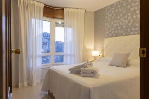 ein Schlafzimmer mit einem Bett mit Handtüchern darauf in der Unterkunft Bleumaison-a mariña portonovo in Portonovo