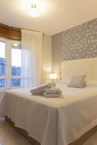 ein Schlafzimmer mit einem weißen Bett mit einem Fenster in der Unterkunft Bleumaison-a mariña portonovo in Portonovo