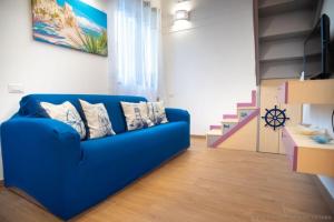 a blue couch in a living room with stairs at Stella Maris House in Cetara