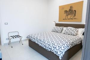 a bedroom with a bed with a horse picture on the wall at Zen Orlando house in Taormina