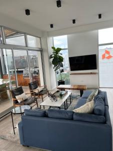 un soggiorno con divano blu e TV a schermo piatto di Apartamento Mónaco a Guatemala