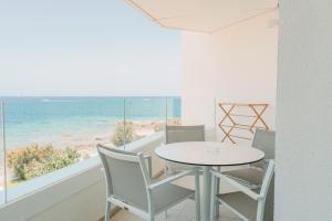 a dining room with a table and chairs and the ocean at Can Salia in San Antonio Bay