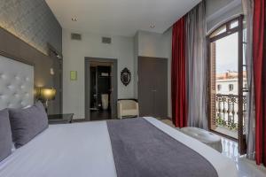 a bedroom with a large bed and a large window at Hotel Ciutadella Barcelona in Barcelona