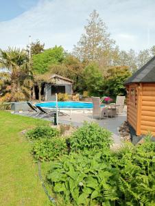 a backyard with a pool and a house at Kota Wadway in Spanbroek