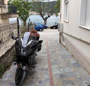 a motorcycle parked on a sidewalk next to a building at Paraliako Κaterina Lakefront - Biker Friendly Hotel in Kastoria