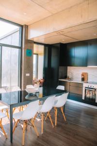 une salle à manger avec une table noire et des chaises blanches dans l'établissement Just Like Home - Quinta de Todos os Dias, à Paredes de Coura