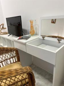 białe biurko z telewizorem i krzesłem w obiekcie Apartmani Sladojević w mieście Mrkonjić Grad