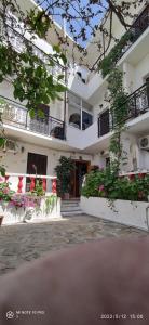 a large white building with flowers in front of it at ODYSSEAS HOTEL SAMOS in Samos