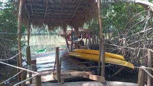 a hut with a raft and a boat on the water at El Puente in El Paredón Buena Vista