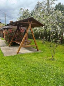 a wooden picnic shelter sitting in a field of grass at Затишок в Карпатах 1 in Slavske