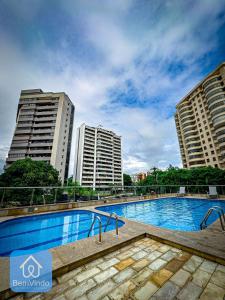 a swimming pool in front of two tall buildings at Apartamento 2/4 completo e aconchegante em Salvador in Salvador