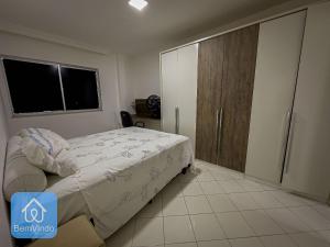 a bedroom with a bed and a closet and a window at Apartamento 2/4 completo e aconchegante em Salvador in Salvador