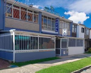 a blue and white building with a gate at Suna Bacata in Bogotá