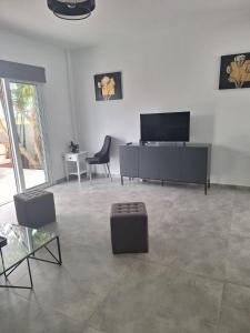 uma sala de estar com uma televisão de ecrã plano e cadeiras em LaVa Villa em Agia Napa