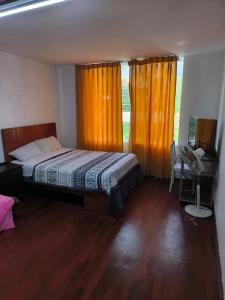 1 dormitorio con cama, escritorio y ventana en Sumaq Wasi Caminos Del Inca en Lima