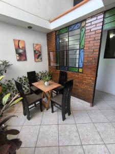 a patio with a table and chairs and a window at Sumaq Wasi Caminos Del Inca in Lima