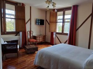 1 dormitorio con 1 cama, 1 silla y ventanas en Antiguas Eras La Alberca, en La Alberca