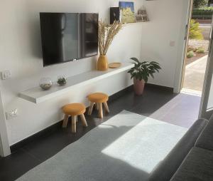 a living room with two stools and a tv at La Casa Gialla in Scardovari