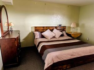 a bedroom with two beds and a dresser with two lamps at The Shepherd’s Nook in Livingston