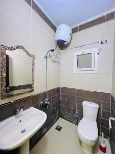 a bathroom with a sink and a toilet and a mirror at Toulay House in Dahab