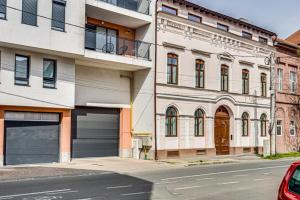 a building with two garage doors on a street at ARI Central Grand Apartment in Arad