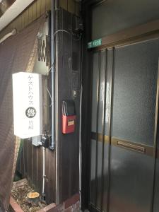 Una puerta a un edificio con un cartel. en Guest House" Ro" takezaki, en Amanogōchō