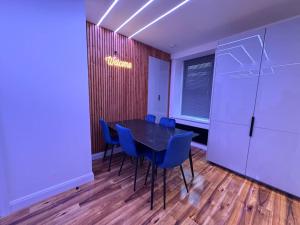 a conference room with a black table and blue chairs at Luxury Hot Tub Retreat Derry City in Derry Londonderry +12 photos