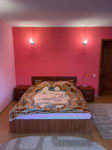 - une chambre dotée d'un lit avec un mur rouge dans l'établissement Cheia Sufletului, 