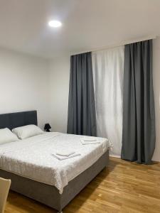 a bedroom with a bed and a large window at N&M Apartment in Pirot