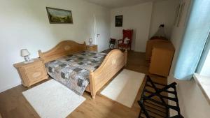 ein Schlafzimmer mit einem Holzbett, einer Kommode und einem Bett sidx sidx sidx in der Unterkunft Lisa's Ferienwohnung in Obing