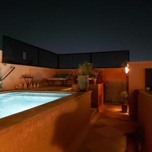 a swimming pool in a house at night at RIAD ANYSSA in Marrakesh