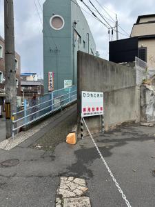 a street with a gate and a sign that says open at Guest House" Ro" takezaki in Amanogōchō