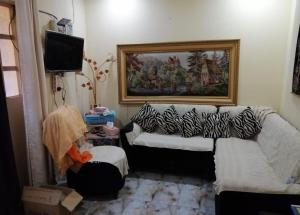 een woonkamer met een bank en een televisie bij LH HOUSE in Amman