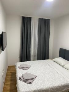a bedroom with a bed with two towels on it at N&M Apartment in Pirot