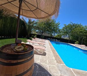 a pool with chairs and a table with an umbrella at Alojamiento turístico Loma Alta in Cambil