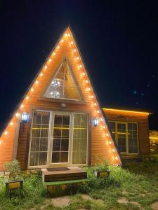 Una casa con luces en el costado. en Fairytale Aframe House en Quba