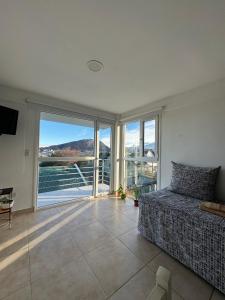 a bedroom with a bed and a balcony with a view at Rincón Montañas del Sur in Ushuaia
