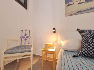 a bedroom with a chair and a bed and a table at Casa Taormina in Letojanni
