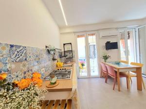 a kitchen with a stove and a table with a dining room at Casa Taormina in Letojanni