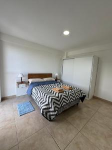 a bedroom with a bed and a refrigerator in it at Rincón Montañas del Sur in Ushuaia