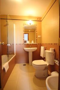 y baño con aseo, lavabo y espejo. en Hostal Niza, en San Juan del Puerto