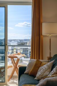 a living room with a couch and a balcony with a view at Sunny 2 BR Aptm with Garden Fast WiFi Walk to Seafront in Il-Gżira