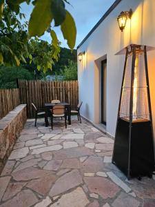 a patio with a table and chairs and a lamp at Vacation Home Domgjon in Rrëshen