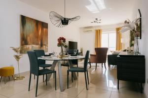 a dining room with a table and chairs at Sunny 2 BR Aptm with Garden Fast WiFi Walk to Seafront in Il-Gżira