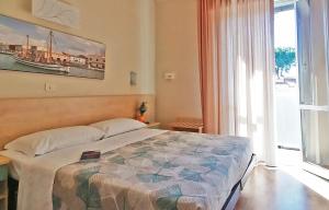 een slaapkamer met een groot bed en een groot raam bij California Pastry Hotel in Cervia
