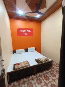 a room with a bed with a sign on it at Agrawal guest house in Ujjain