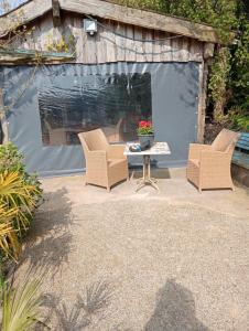 a patio with two chairs and a table in a backyard at Kota Wadway in Spanbroek