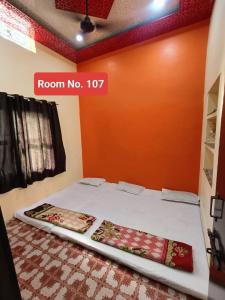 a bed in a room with an orange wall at Agrawal guest house in Ujjain